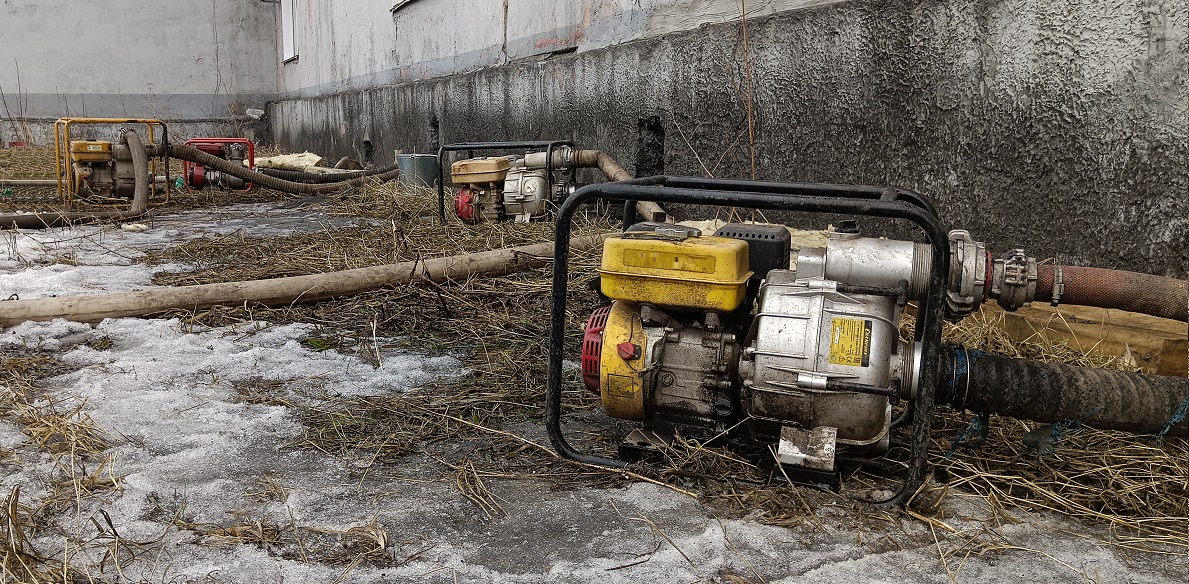 Откачка мотопомпами талой воды из подвала дома в Десногорске